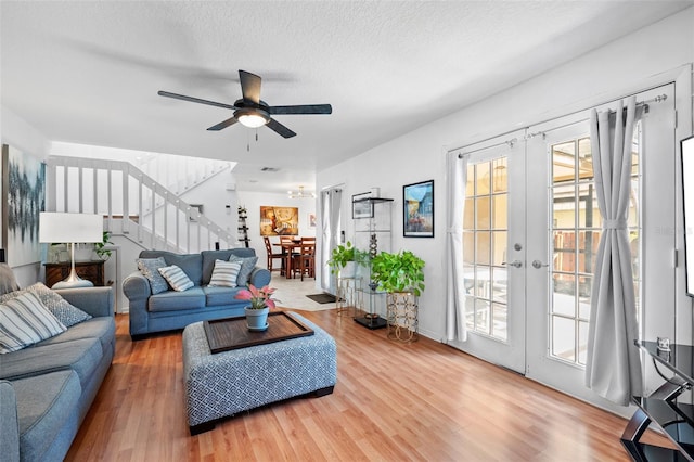 living room featuring hardwood / wood-style floors, french doors, a textured ceiling, and ceiling fan