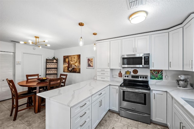 kitchen featuring light stone counters, decorative light fixtures, kitchen peninsula, stainless steel appliances, and white cabinets