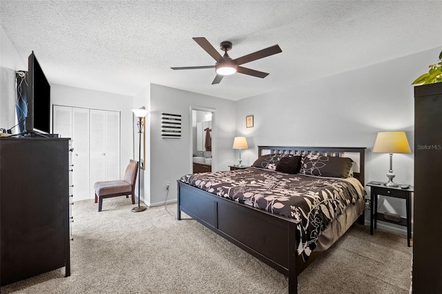 bedroom with ensuite bath, a textured ceiling, carpet floors, a closet, and ceiling fan