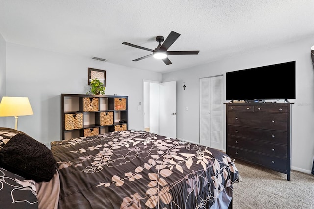 carpeted bedroom featuring ceiling fan, a closet, and a textured ceiling