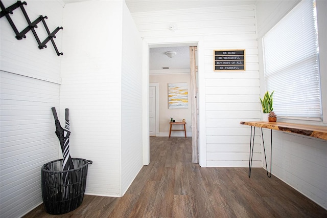 hallway with dark hardwood / wood-style flooring and ornamental molding