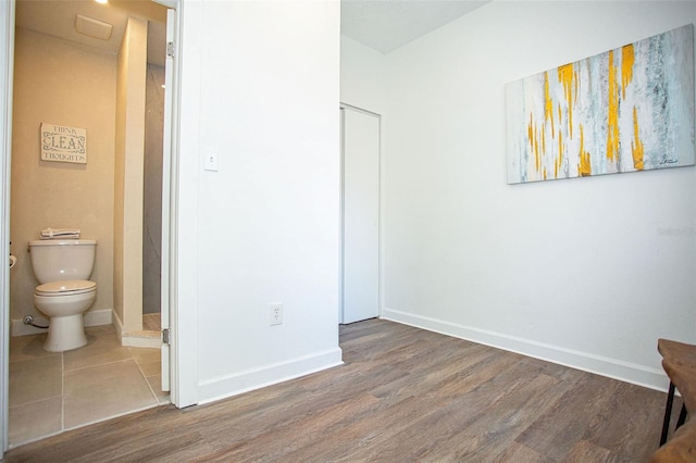 bedroom with connected bathroom and hardwood / wood-style floors