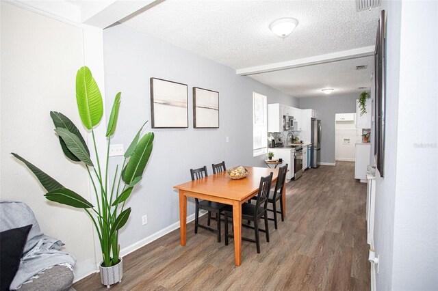 dining space with dark hardwood / wood-style flooring and a textured ceiling