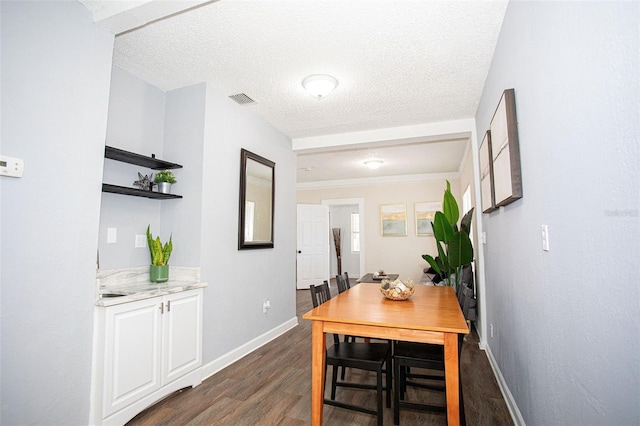 dining area featuring dark hardwood / wood-style flooring and a textured ceiling