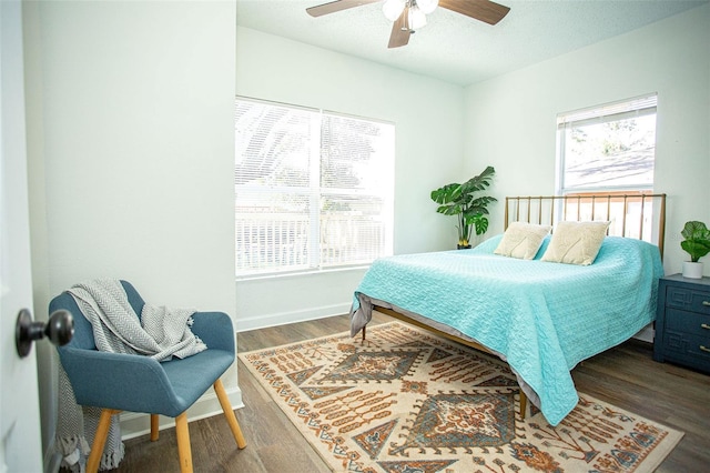 bedroom featuring ceiling fan, dark hardwood / wood-style flooring, and a textured ceiling