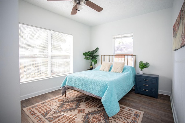 bedroom with ceiling fan, dark hardwood / wood-style floors, and a textured ceiling