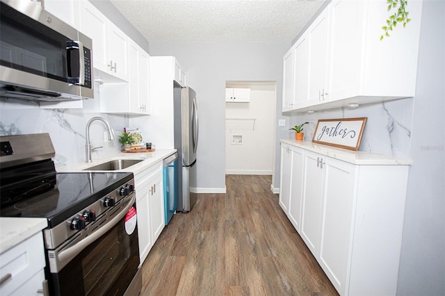 kitchen with sink, a textured ceiling, white cabinets, and appliances with stainless steel finishes