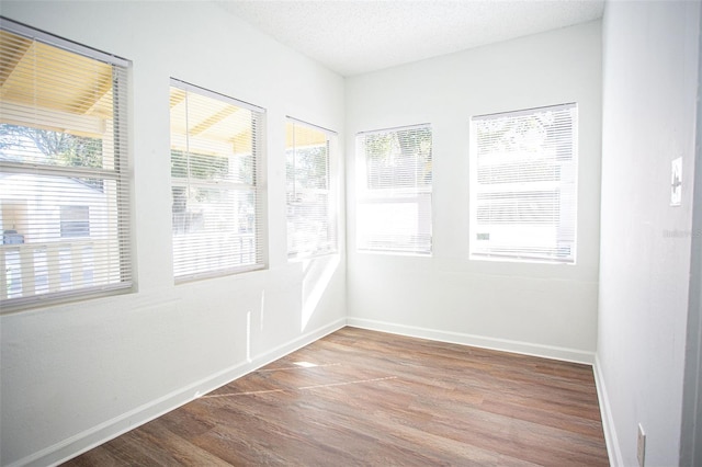 empty room with hardwood / wood-style flooring and a textured ceiling