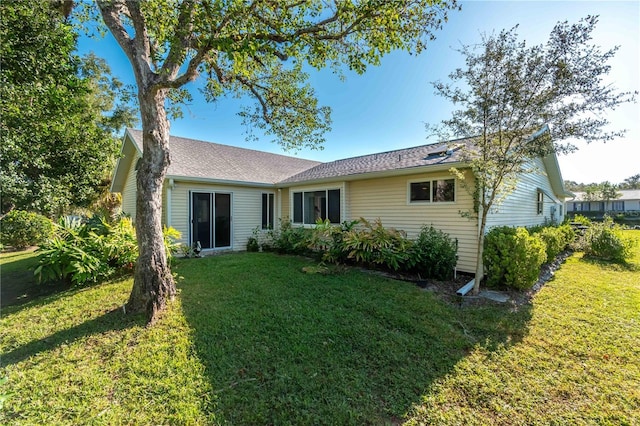 rear view of property with a lawn