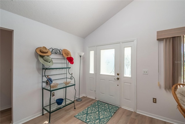 foyer entrance featuring light hardwood / wood-style flooring and vaulted ceiling