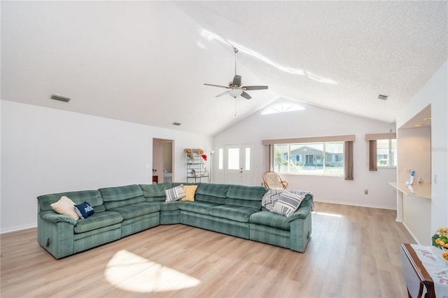 living room with ceiling fan, lofted ceiling, light hardwood / wood-style flooring, and a textured ceiling