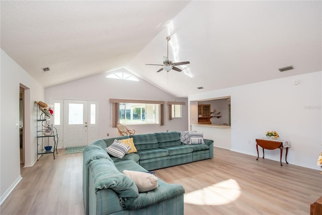 living room with vaulted ceiling, ceiling fan, and light hardwood / wood-style flooring