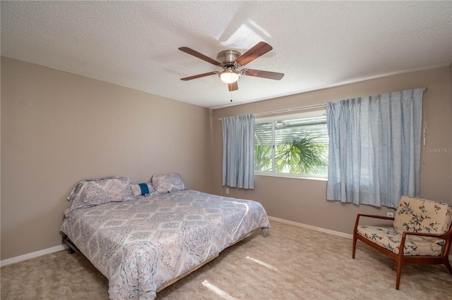 carpeted bedroom with ceiling fan and a textured ceiling