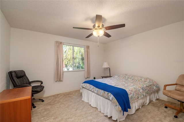 carpeted bedroom featuring a textured ceiling and ceiling fan