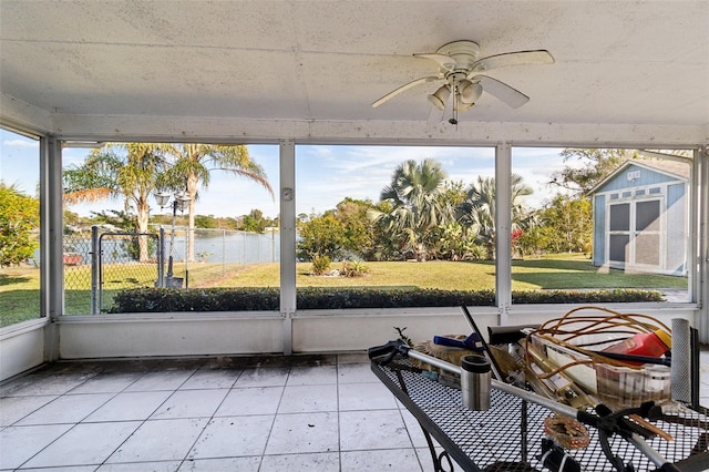 sunroom / solarium featuring a water view and ceiling fan