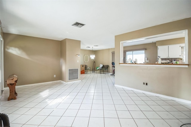 unfurnished living room with light tile patterned flooring and a chandelier