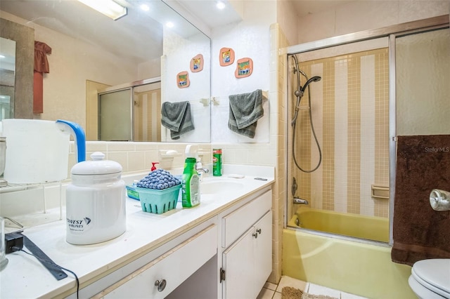 full bathroom featuring vanity, combined bath / shower with glass door, backsplash, and toilet