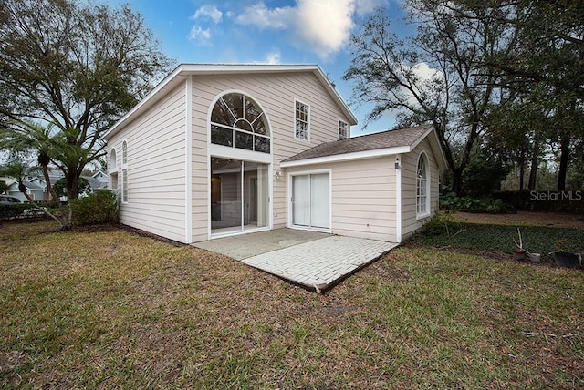 rear view of house with a yard and a patio area