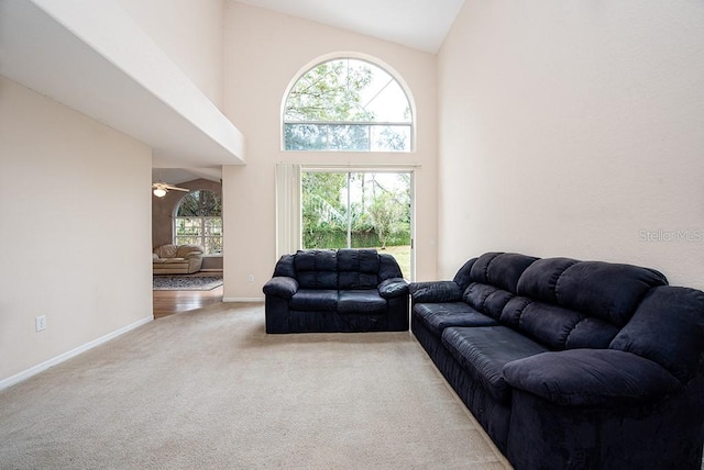 carpeted living room featuring high vaulted ceiling