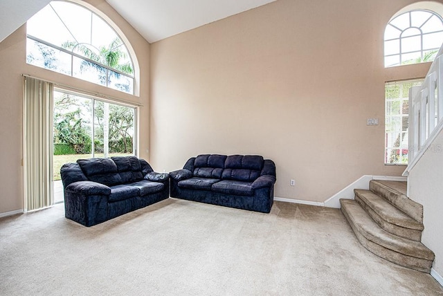 carpeted living room featuring a wealth of natural light and high vaulted ceiling