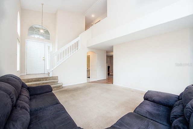 carpeted living room with a towering ceiling