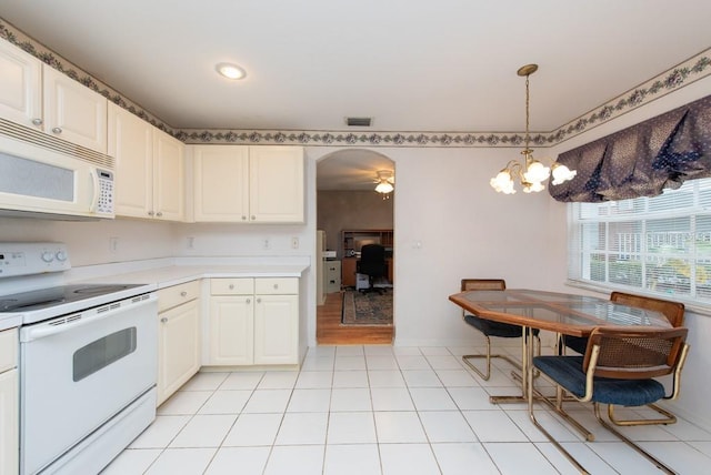 kitchen featuring light tile patterned floors, a notable chandelier, white appliances, and decorative light fixtures