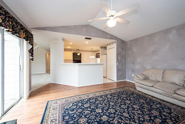 unfurnished living room featuring lofted ceiling, light hardwood / wood-style floors, and ceiling fan