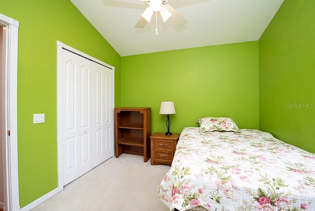 bedroom featuring ceiling fan, lofted ceiling, light colored carpet, and a closet