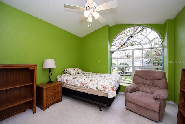 carpeted bedroom with ceiling fan and vaulted ceiling