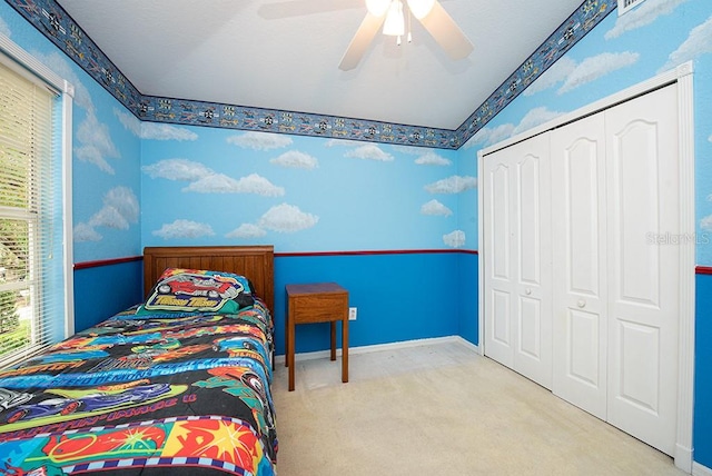 bedroom with light colored carpet, ceiling fan, vaulted ceiling, and a closet