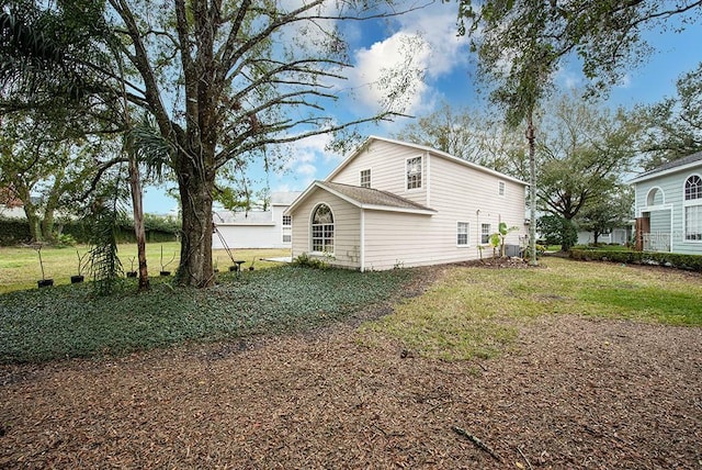 rear view of house featuring a yard