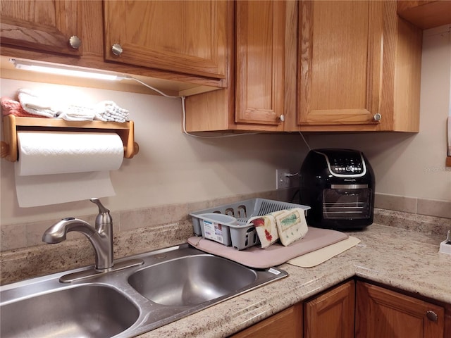 kitchen featuring light stone countertops and sink