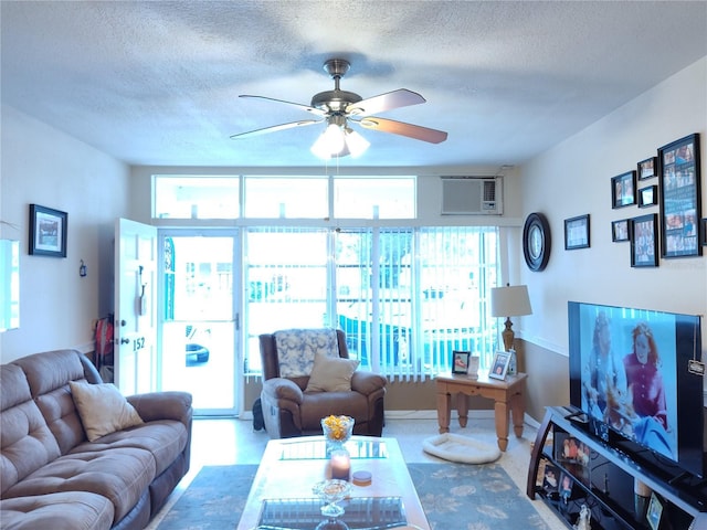 living room with ceiling fan, an AC wall unit, and a textured ceiling