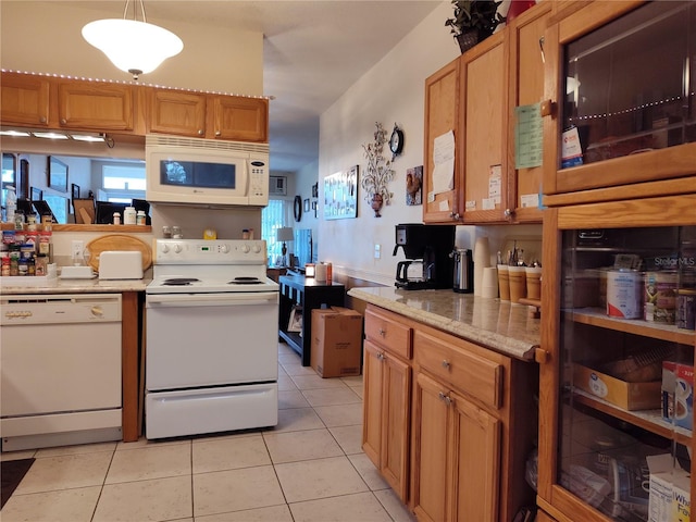 kitchen featuring white appliances, hanging light fixtures, and light tile patterned floors