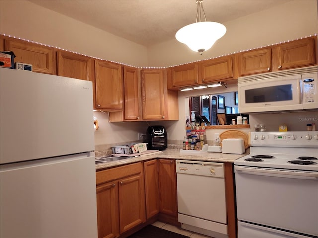 kitchen with white appliances, decorative light fixtures, and light tile patterned floors