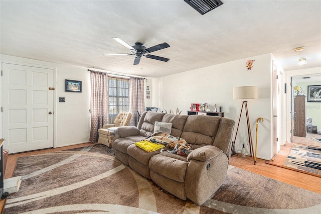 living room featuring hardwood / wood-style floors, a textured ceiling, and ceiling fan