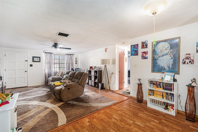 living room featuring hardwood / wood-style floors and ceiling fan