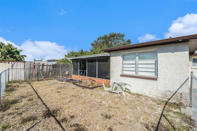 back of property featuring a yard and a sunroom