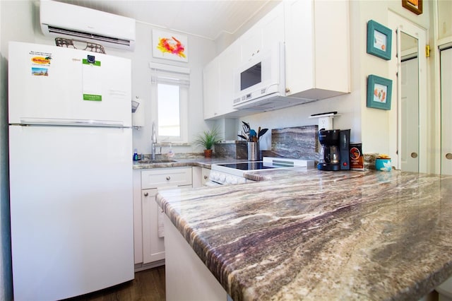 kitchen with a wall mounted air conditioner, sink, white cabinets, kitchen peninsula, and white appliances