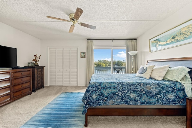 bedroom with a textured ceiling, light carpet, access to outside, a closet, and ceiling fan