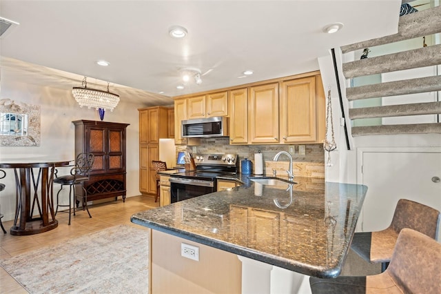 kitchen with tasteful backsplash, sink, dark stone counters, and appliances with stainless steel finishes