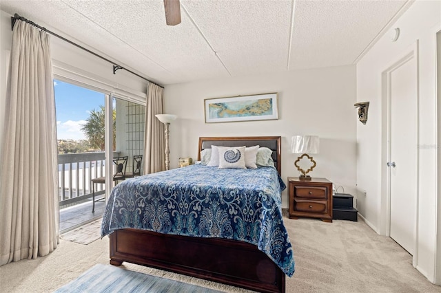 bedroom featuring ceiling fan, carpet, access to exterior, and a textured ceiling