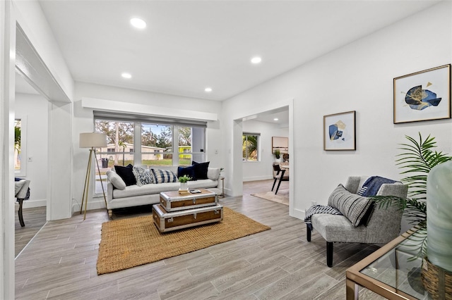 living room with baseboards, recessed lighting, and light wood-style floors