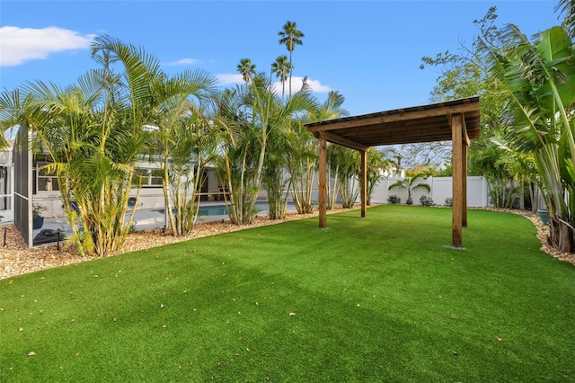 view of yard with glass enclosure, a fenced backyard, and a fenced in pool