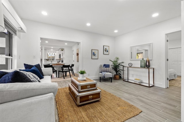 living area featuring light wood finished floors, baseboards, and recessed lighting