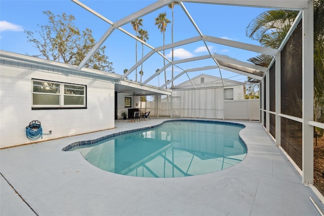 outdoor pool with ceiling fan, a patio, and glass enclosure