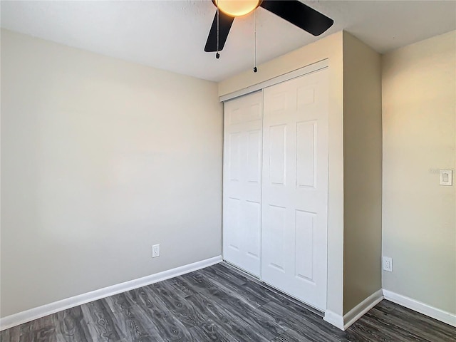 unfurnished bedroom with dark wood-type flooring, a closet, and ceiling fan