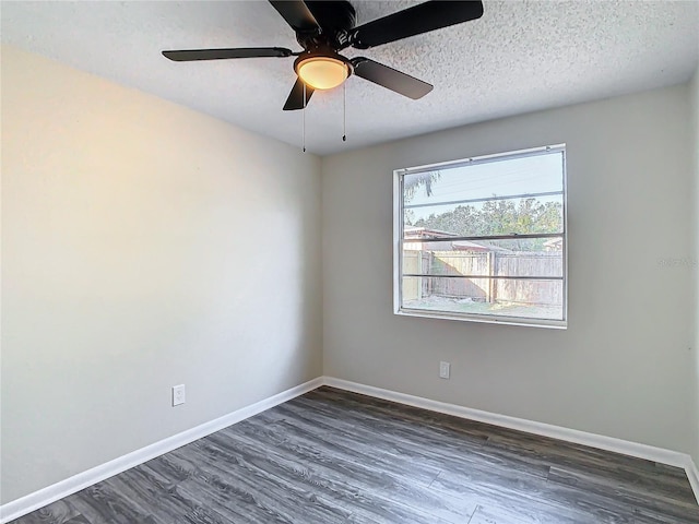 empty room featuring ceiling fan, dark wood-type flooring, and a textured ceiling