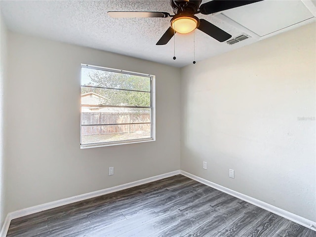 empty room featuring ceiling fan, dark wood-type flooring, and a textured ceiling