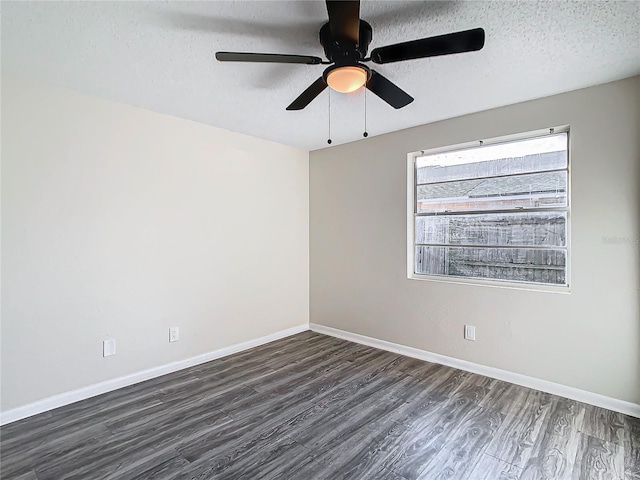 empty room with dark hardwood / wood-style flooring and a textured ceiling